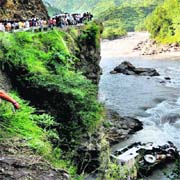 People watch the ill-fated bus that fell into the Tons river at Tyuni near Dehradun on Sunday.