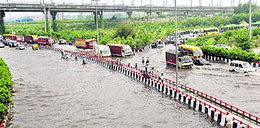 Vehicles stuck at a flooded road near Laxmi Nagar after a downpour in New Delhi on Friday.