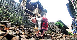 A woman clears rubble to make way for pedestrians after the earthquake in Kathmandu.