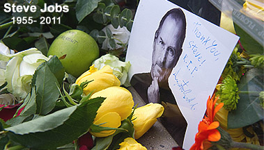 Flowers, apples, and candles placed as a tribute to the Apple co-founder outside a company store in central London on Thursday. Computing legend Steve Jobs died of pancreatic cancer in California late on Wednesday surrounded by family. 
