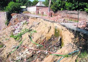 A portion of the Sham Singh road which caved in has blocked the sewerage line