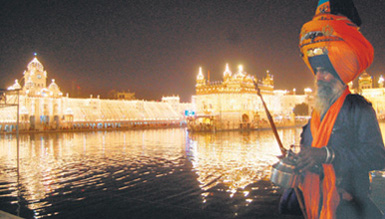 A Nihang in traditional finery pays his respects at the illuminated Golden Temple on Diwali eve in Amritsar on Tuesday.