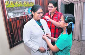 Dr Gurvinder Kaur, medical officer at the Civil Hospital, being readied for duty by her children