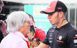 McLaren-Mercedes driver Lewis Hamilton of Britain (R) speaks with Formula One supremo Bernie Ecclestone (L) at the paddock a day before the practice sessions of Formula One's Indian Grand Prix at the Buddh International circuit in Greater Noida on Thursday