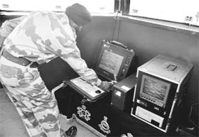 A soldier operates an equipment to look across the LAC