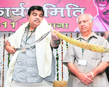 BJP all-India president Nitin Gadkari takes out a sword during the state executive meeting in Ludhiana. On the right is Shanta Kumar, BJP in charge, Punjab. 