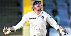 Mahendra Singh Dhoni celebrates the dismissal of West Indies' Marlon Samuels during the first day of the first Test in New Delhi on Sunday. 
