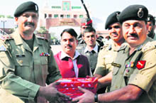 DIG BSF Sanjeev Bhanot (R) hands over sweets to Wing Commander Sohail Khan, Pakistan Rangers, on the occasion of Eid-ul- Zuha at the Indo-Pak Attari Wagha checkpost near Amritsar