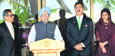 Prime Minister Manmohan Singh speaks to the Press as his Pakistan counterpart Syed Yusuf Raza Gilani (2R) looks on after their meeting in Addu on Thursday