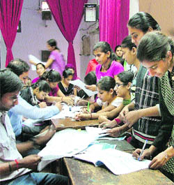 Girls fill in forms to open a bank account at the Government College for Women.