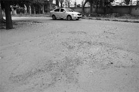 Poor condition of a road in Phase IX