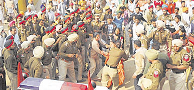 Cops take away a protesting woman who tried to stop CM Parkash S Badals motorcade in Muktsar.