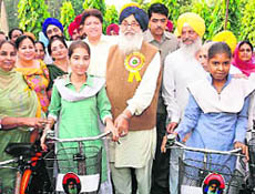 Punjab Chief Minister Parkash Singh Badal hands over cycles to schoolgirls. 