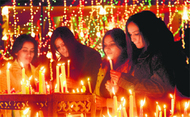 Girls light candles at a church in Chandigarh on Sunday. 