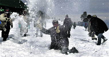 Tourists enjoy snow at the Kangdoori skiing resort near Gulmarg, 55 km from Srinagar, on Monday.