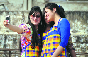 Two girls photograph themselves with their mobile phone in Ludhiana.