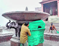 Workers engaged in draping the statues of elephants