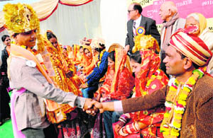 A bridegroom shakes hands with another during a mass marriage in Sector 20, Chandigarh, on Saturday.