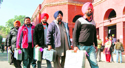 Poll officials carry electronic voting machines in Amritsar on Sunday.