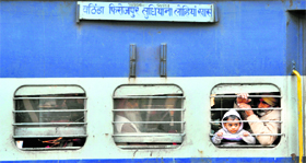 Wearing a woollen cap, a little boy peeps through the window of a train in Ludhiana.