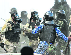 A Maldives police officer clashes with soldiers in Male on Tuesday.
