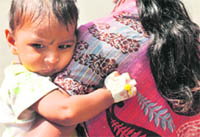 A woman with her daughter outside the emergency block of the Government Gandhi Hospital in Hyderabad on Saturday.