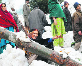  Residents clear snow after an avalanche at Ramwari village in Ganderbal district on Thursday. 