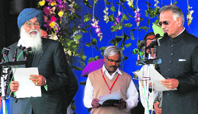 Punjab Governor Shivraj Patil (R) administers the oath of office to Parkash Singh Badal  at Chappar Chiri village in Mohali district on Wednesday. 