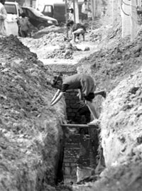 A slum child tries to cross an uncovered drain at Sector 9 in Panchkula.