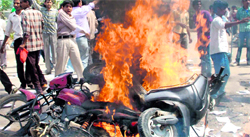 Workers burn vehicles outside a factory in Gurgaon on Monday.