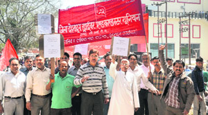 Members of the District Dehradun Driver Conductor Union hold a protest in Dehradun