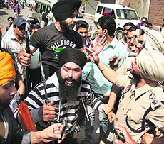 A police officer tries to snatch a sword from a demonstrator in Jalandhar.