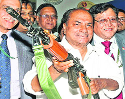 Defence Minister AK Antony holds a machine gun at Defexpo India 2012