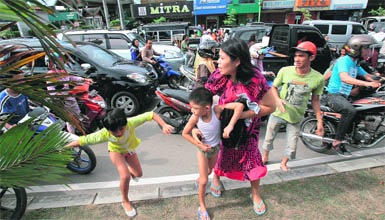 Acehnese people run shortly after a powerful earthquake hit western coast of Sumatra in Banda Aceh