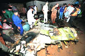Rescue workers and local residents at the crash site near Islamabad on Friday.