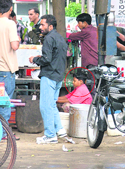 A child (circled) ekes out a living by working in an eatry run by a roadside vendor and by washing utensils in Ludhiana.
