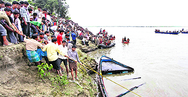 Rescue workers pull a part of a damaged boat to the shore after it sank in the Brahmaputra at Buraburi village in Dhubri district of Assam on Tuesday. Rescue workers fought heavy rain to search for survivors.