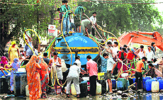 People collect drinking water from a tanker at Okhla in New Delhi on Sunday. 