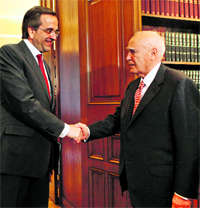 President Karolos Papoulias (R) welcomes leader of the conservative New Democracy party Antonis Samaras in his office in Athens on Monday.