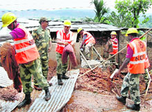 Members of NDRF carry out a rescue operation after a house caved-in following a lanslide at Lalung Gaon near Gorchuk in Guwahati on Friday