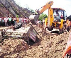 A JCB digs out one of the vehicles swept away in the flash flood in Paonta Sahibs Haripur Khol panchayat area on Saturday.