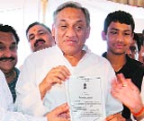 Uttarakhand CM Vijay Bahuguna with the election certificate after his victory. 