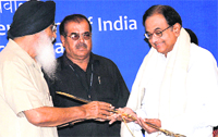Punjab CM Parkash Singh Badal presents a sword  to Home Minister P Chidambaram in Chandigarh on Friday.