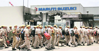 Police force entering the violence-hit Maruti Suzuki plant in Manesar on Saturday.  PTI