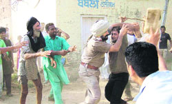 A resident clashes with a cop in Akalia village of Mansa district on Tuesday.  A Tribune photograph