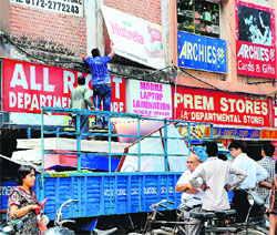 Employees of the MC remove signboards at the market of Sector 15 in Chandigarh on Friday. As many as 80 boards were removed in the markets of Sectors 15, 22 and 35 for violation of the provisions of the Chandigarh Advertisement Control Order-1954.