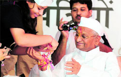 A supporter of Anna Hazare ties a 'rakhi' on his wrist on the fifth day of his hunger strike in New Delhi.