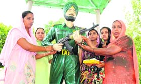 Surjit Kaur and Baljit Kaur tie Rakhis on the statue of Paramjeet Singh on Thursday
