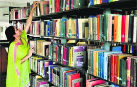 A woman selects book at the PAU library