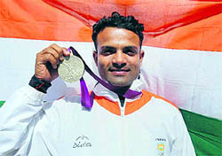 Vijay Kumar poses with the silver medal he won in the 25m rapid fire pistol mens final in London on Friday